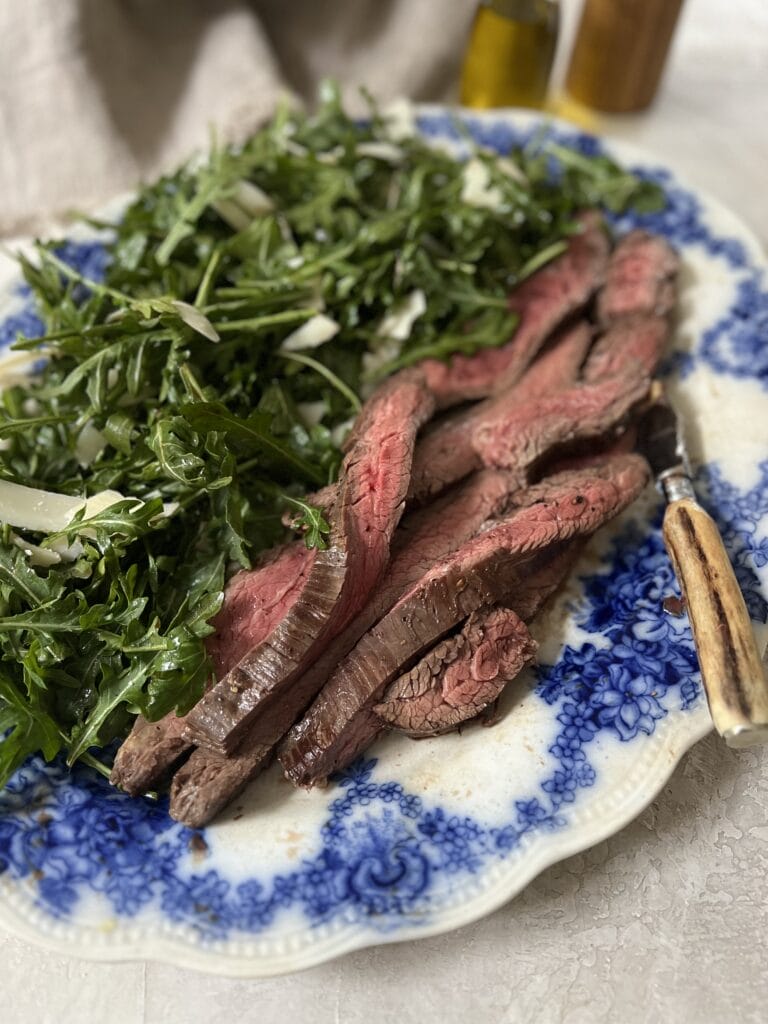 steak on arugula with balsamic and parmesan