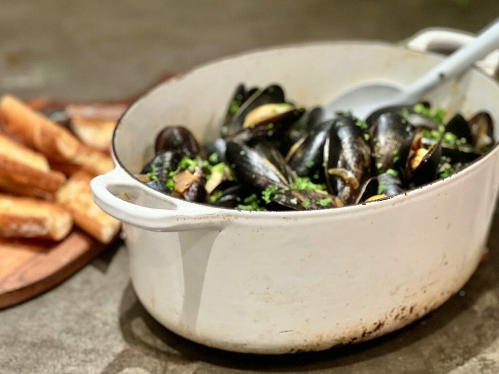 White Dutch oven with Mussels in White Wine and Garlic with toasted baguette
