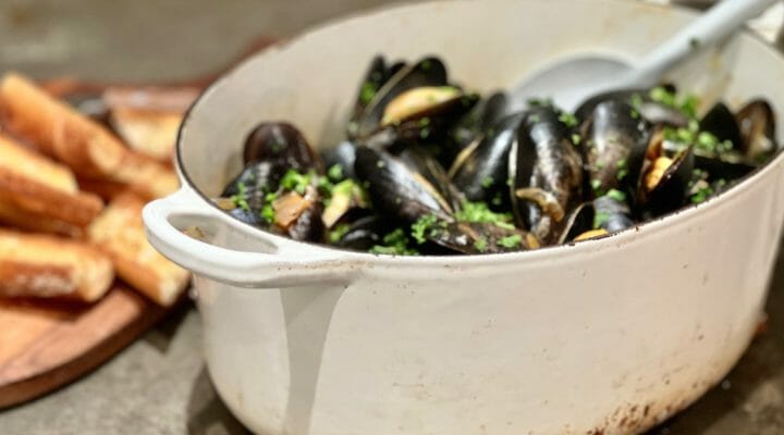 White Dutch oven with Mussels in White Wine and Garlic with toasted baguette