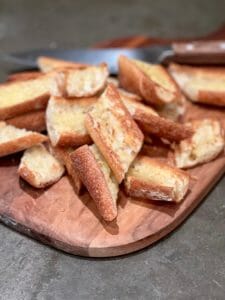 Board with toasted baguette for easy mussels recipe