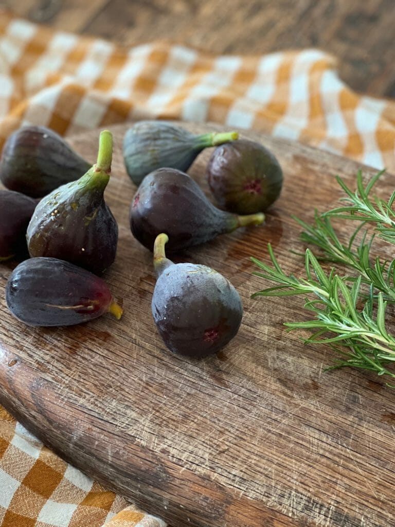 figs and rosemary on a cutting board