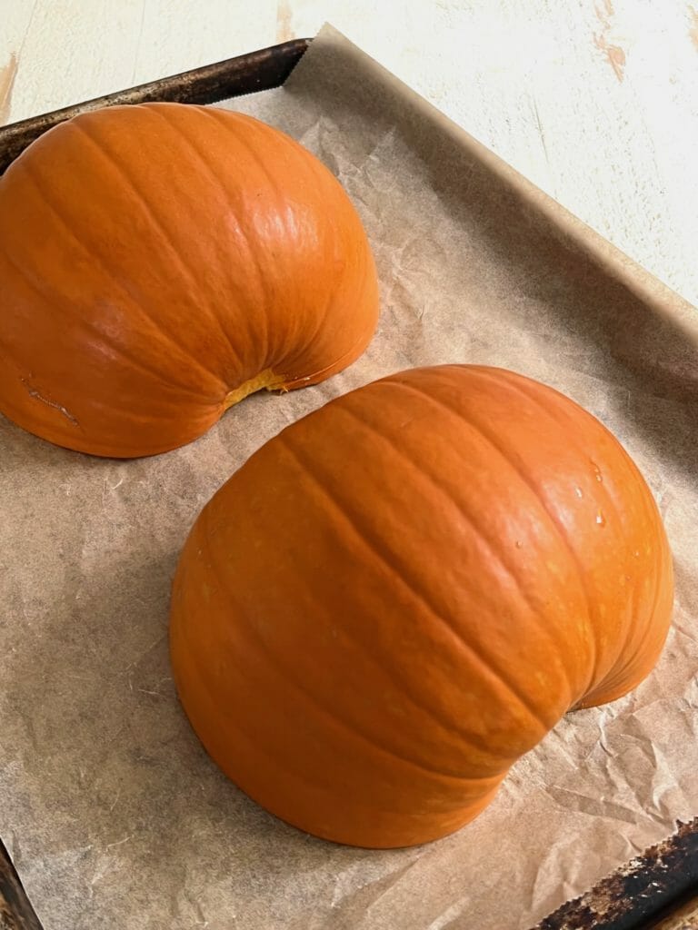 Halved pumpkin on a baking sheet