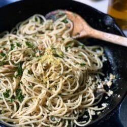 Spaghetti and clams in a cast iron skillet with a spoon