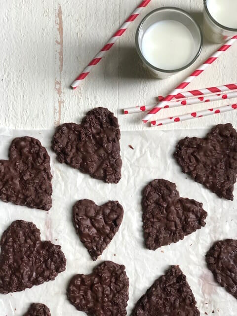 chocolate coconut treats on a white background with glasses of milk and red and white straws