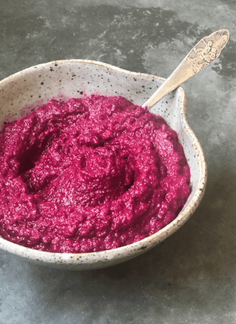 beet Hummus in bowl with spoon