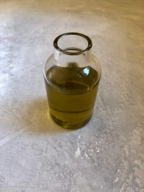 small glass container of olive oil, one of five best oils and fats for cooking