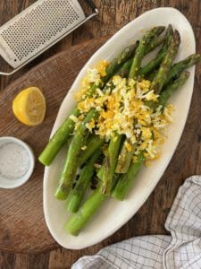 White plate withe asparagus and lemon and egg