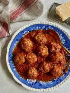 Turkey meatballs on a vintage blue plate with Parmesan cheese