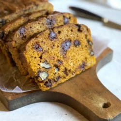 slices of slow cooker pumpkin bread on parchment paper on a bread board