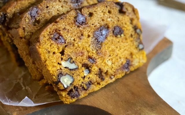 slices of slow cooker pumpkin bread on parchment paper on a bread board