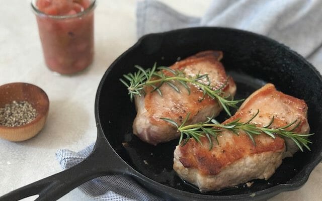 Pork Chops in a cast iron skillet with rosemary and rhubarb compot