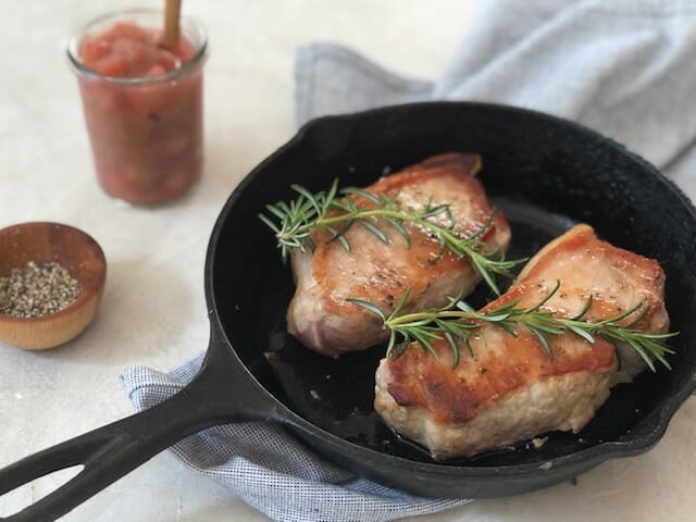 Pork Chops in a cast iron skillet with rosemary and rhubarb compot