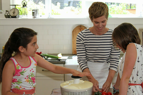 mom and children making salad with green goddess dressing