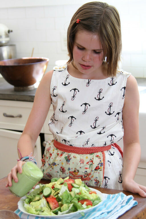 young girl in the kitchen making green goddess dressing