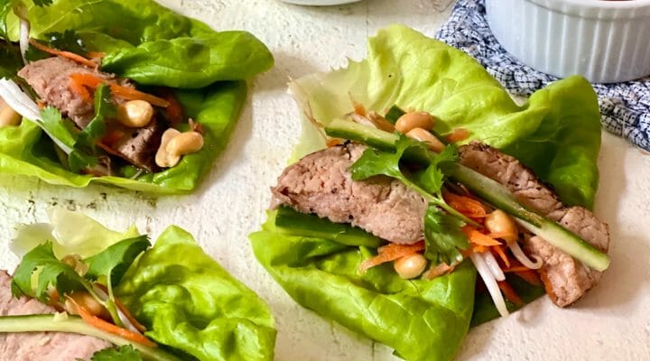 Pork lettuce wraps with dressing and peanuts on the side