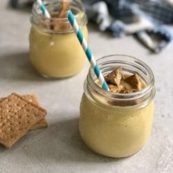 two glasses of pumpkin pie milkshake with graham cracker topping and striped blue straws