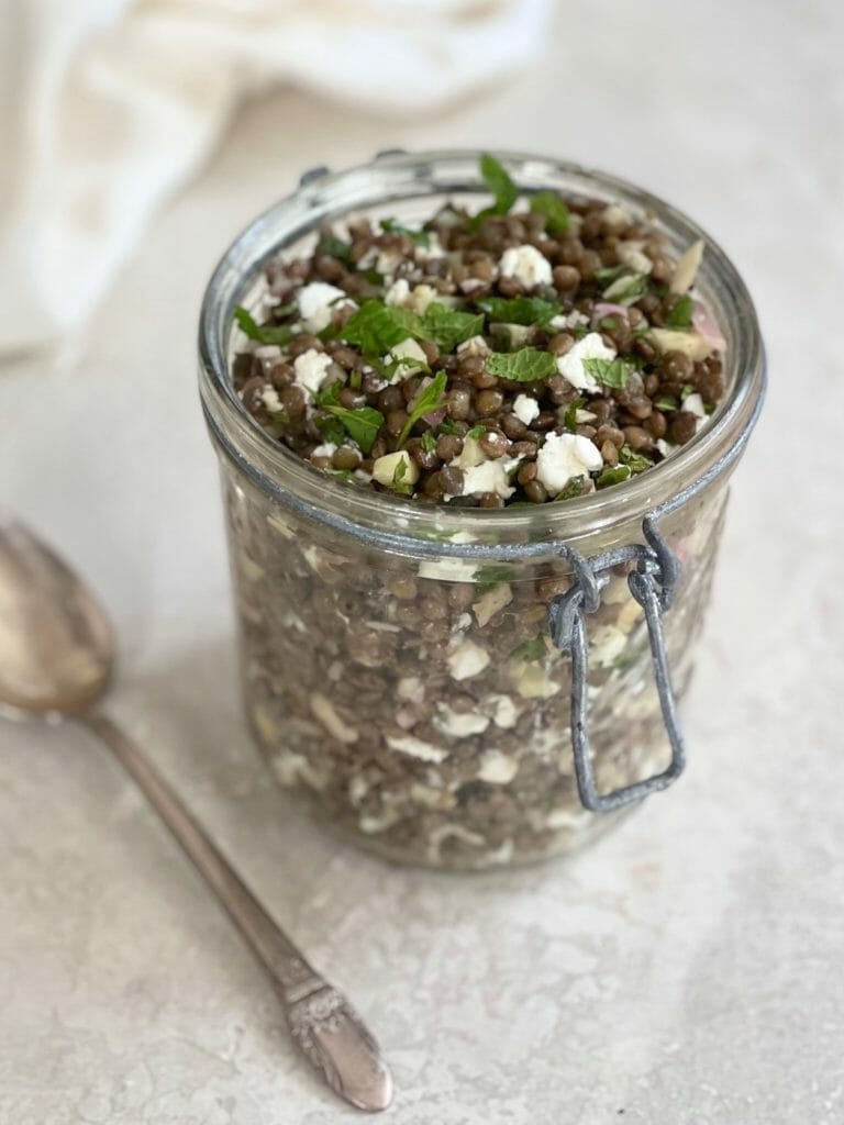 Glass jar of French Lentil salad with a spoon