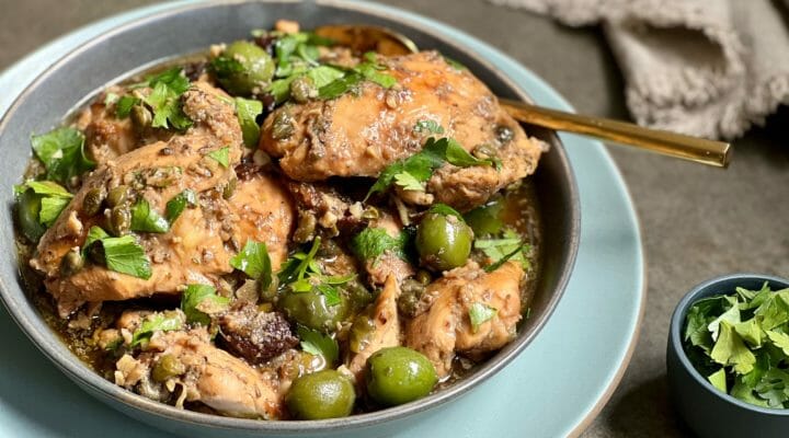 Slow cooker chicken marbella on a plate with parsley garnish