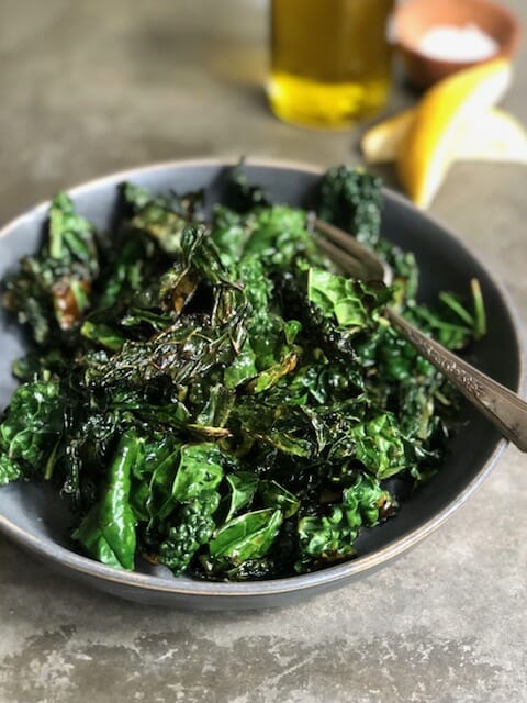 bowl of sauteed kale with olive oil, lemon, and salt