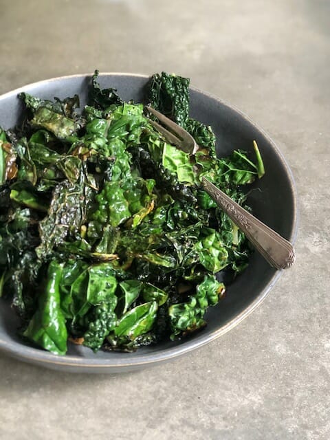 Sautéed kale in a bowl with a fork