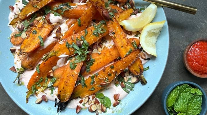 roasted carrots with yogurt with a dish of harissa and mint on the side.
