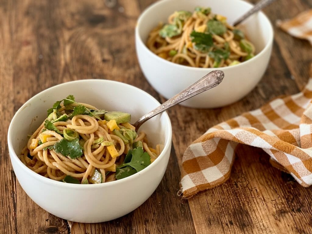 Noodles with peanut sauce in white bowls