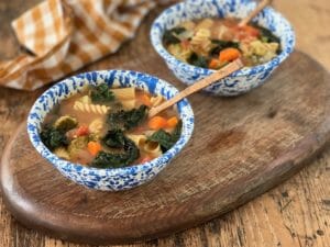 two bowls of minestrone with spoons