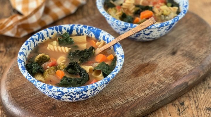 two bowls of minestrone with spoons