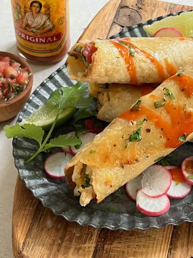 Crispy Baked Chicken Taquitos with hot sauce