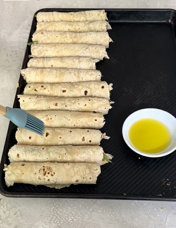 Sheet pan of chicken taquitos read to bake