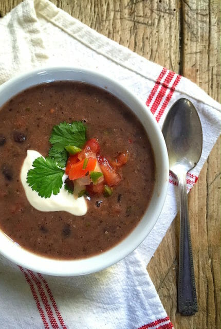 black bean soup with salsa and sour cream in a white bowl