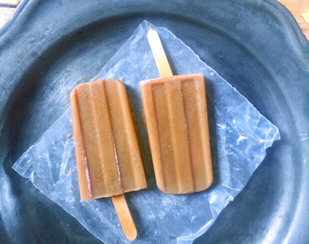 two cafe con leche ice pops on a grey plate