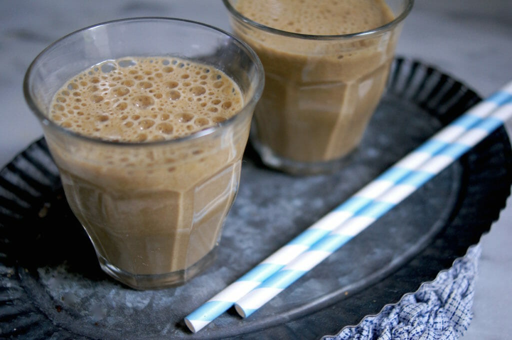 Two glasses of healthy Peanut Butter Chocolate Smoothie with blue striped straws