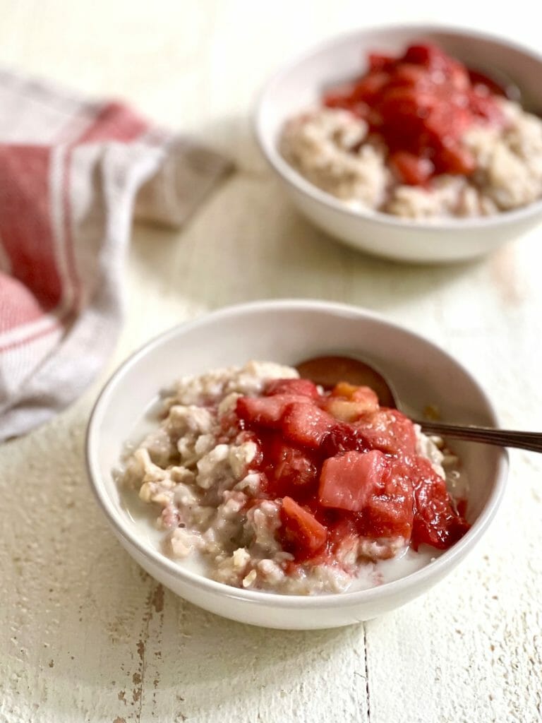 two bowls of oatmeal with strawberry rhubarb compote