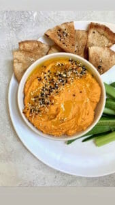 Bowl of sweet potato hummus with pita chips and vegetables