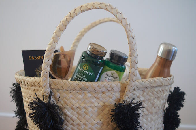 Travel Essentials in a Straw Tote Bag