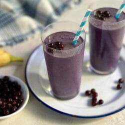 two glasses of wild blueberry smoothie with straws
