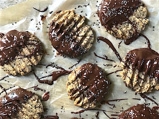 Healthy Tahini Almond Butter Cookies dunked in dark chocolate with chocolate drippings