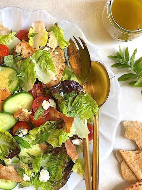 Fattoush Salad on a plate with salad tongs