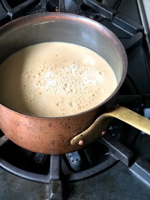 Warming chai on the stove in a copper pot