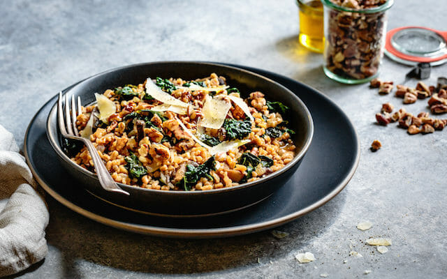 Instant Pot Farro Risotto with parmesan and kale in a shallow grey bowl