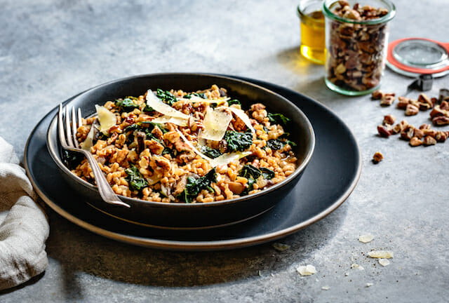 Instant Pot Farro Risotto with parmesan and kale in a shallow grey bowl