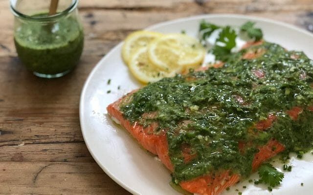 salmon served with green sauce on a white plate or summer vegetable salad served on a plate