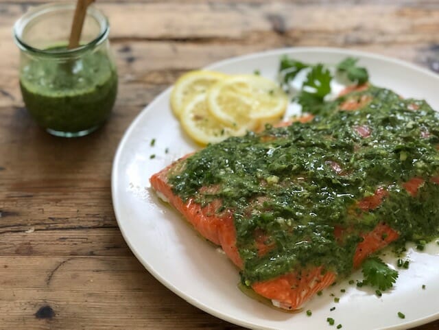 salmon served with green sauce on a white plate or summer vegetable salad served on a plate