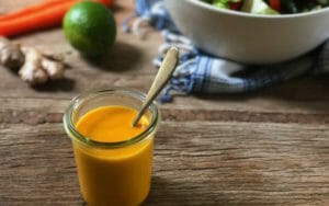 carrot miso dressing in a glass jar with a spoon