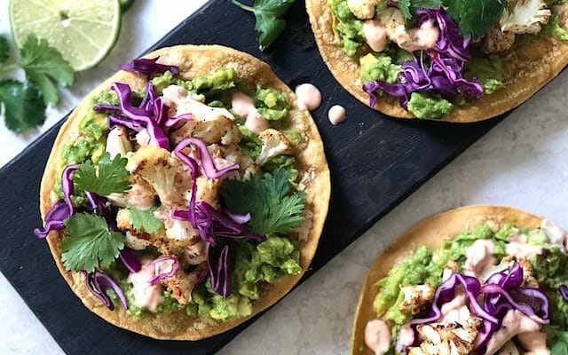 Cauliflower tostadas with avocado, cabbage and chipotle cream with lime slices