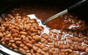 Slow Cooker Pinto Beans in a pot with a big spoon