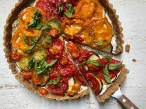 Tomato Zucchini Tart with a spatula and wedge of tart