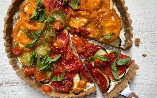 Tomato Zucchini Tart with a spatula and wedge of tart