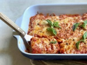 Oven Baked Tofu Parmesan with a spatula in a baking dish